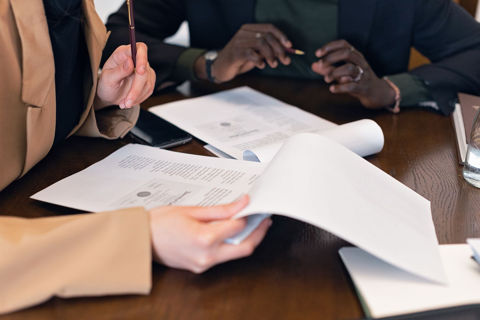 Consultants reviewing visa application documents line by line across a desk